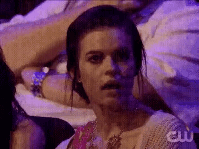 a woman is sitting in a dark room with purple lights .
