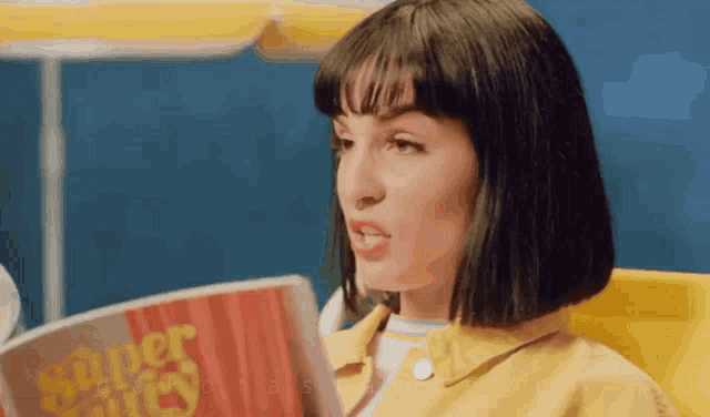 a woman in a yellow jacket is reading a book called super chicks