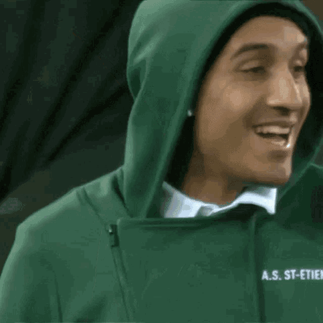 a man wearing a green hoodie that says a.s. st-etienne is smiling