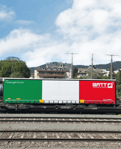 a green white and red train car with the word gatt on the side