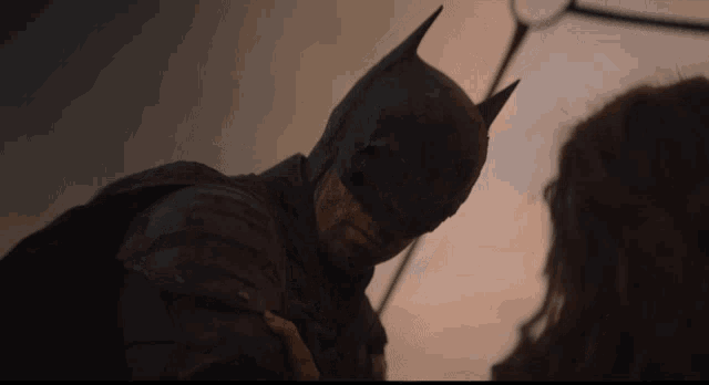 a close up of a man in a batman costume looking down
