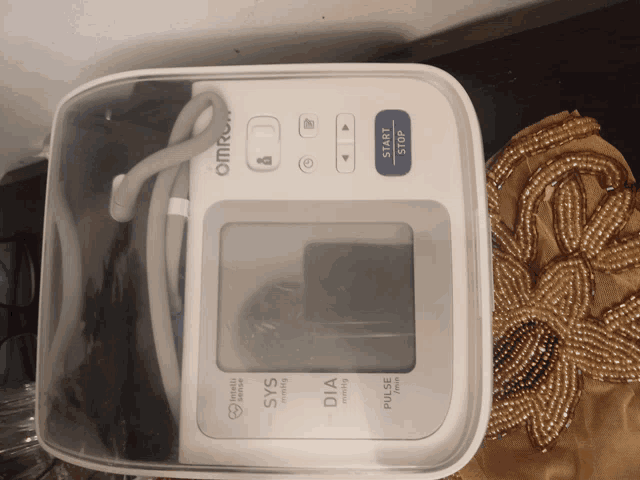 an omron brand blood pressure monitor sits in a clear case