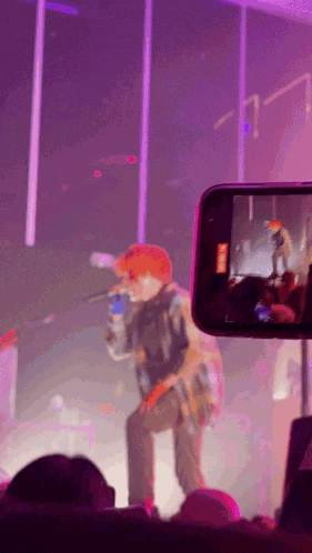 a phone is taking a picture of a man on stage