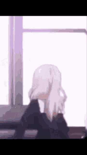 a girl with white hair is sitting in front of a window .