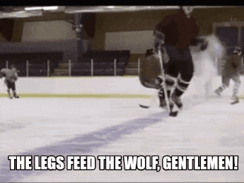 a group of hockey players are playing on a rink with the words the legs feed the wolf gentlemen .