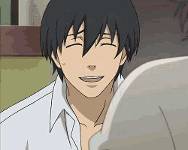 a man with black hair is smiling in a white shirt
