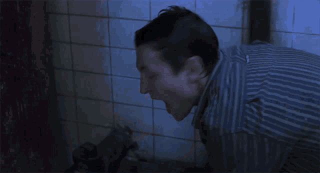 a man is screaming in a dark room with his mouth open