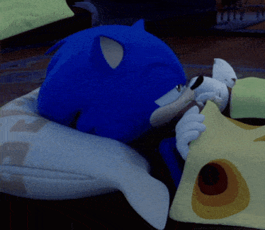 sonic the hedgehog is laying on a pillow with a dolphin shaped pillow