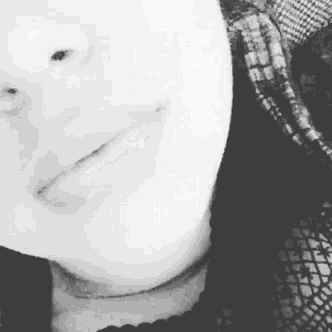 a black and white photo of a woman 's face and neck