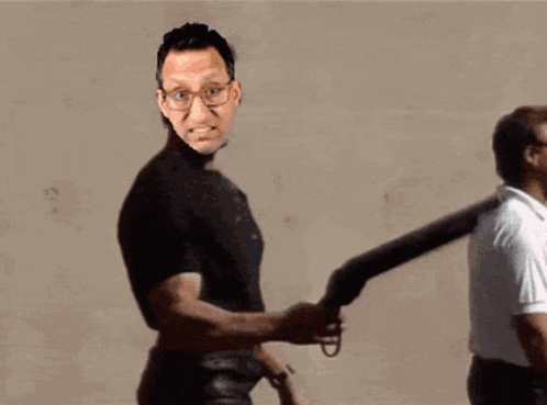 a man in a black shirt is pointing at another man with an umbrella