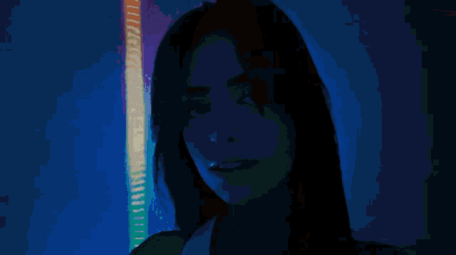 a woman with her eyes closed in front of a blue wall