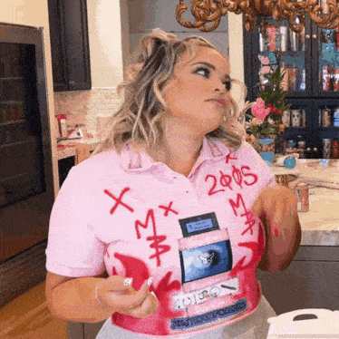 a woman is wearing a pink shirt that says 2005 on it