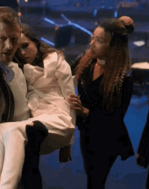 a man is carrying a woman in a white dress