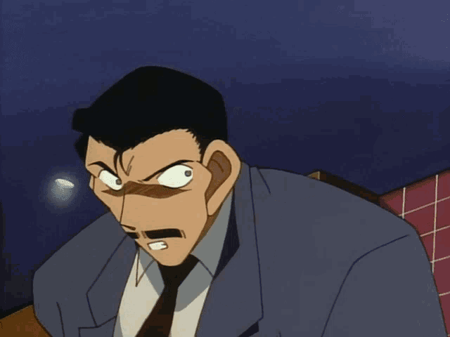 a man in a suit and tie is making a very angry face