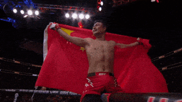 a man is wrapped in a red and yellow flag with the word ufc on the shorts