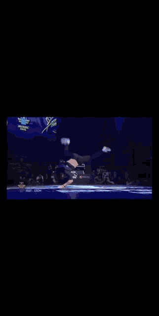a person doing a handstand on a stage with a red bull logo