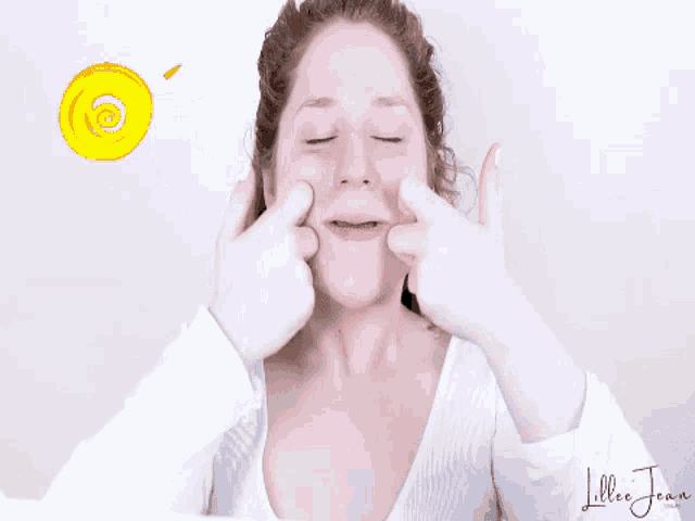 a woman with her eyes closed is touching her face in front of a drawing of a sun