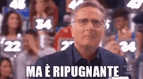 a man wearing glasses is standing in front of a crowd of people and says `` ma e ripugnonte '' .