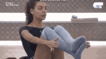 a woman wearing blue socks is sitting on the floor