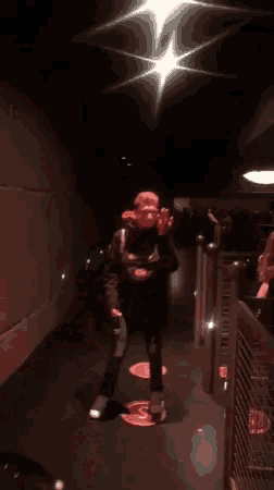 a person is standing in a dark hallway with a red light shining on them