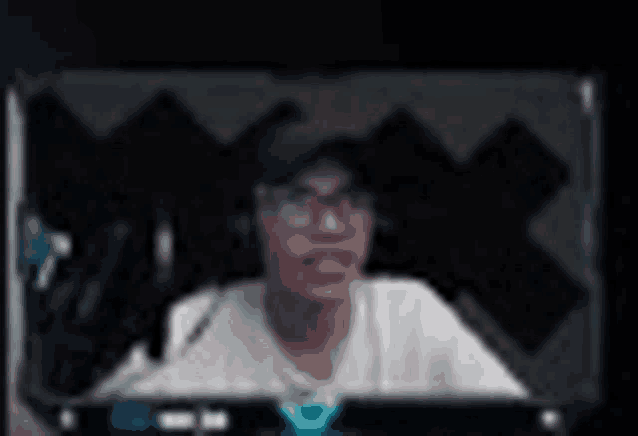 a blurry picture of a man wearing glasses and a hat on a computer screen .