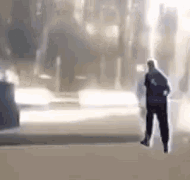 a man is standing on a sidewalk in front of a building in a blurry photo .