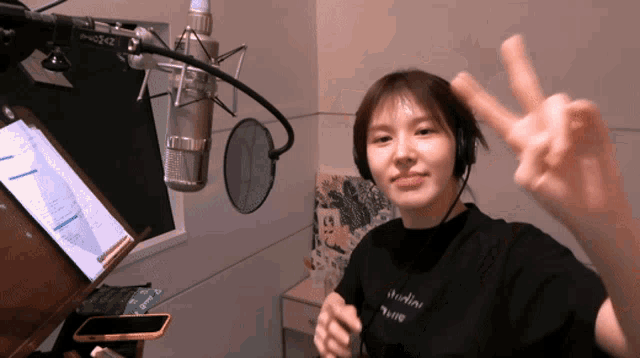 a woman wearing headphones and a black shirt that says studio