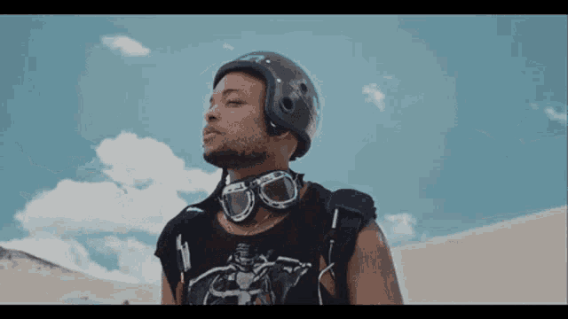 a man wearing a helmet and goggles looks at the sky