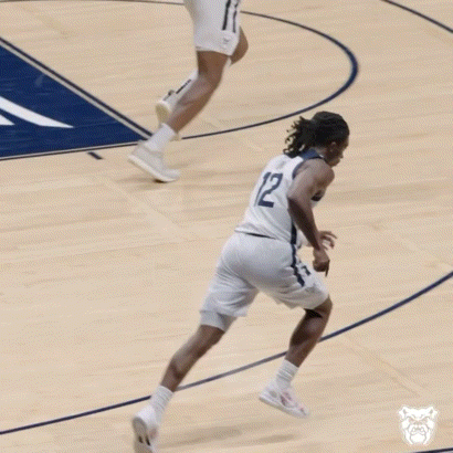 a basketball player with the number 12 on his jersey is running on the court