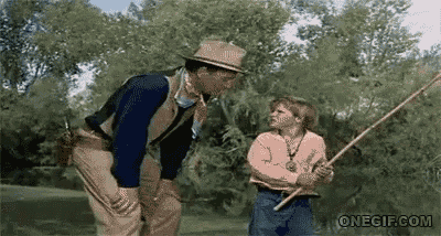 a man and a little girl are standing next to each other holding a fishing rod .