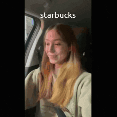 a woman is sitting in a car with the words starbucks written on her face