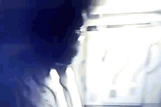 a blurry picture of a person standing in front of a window .