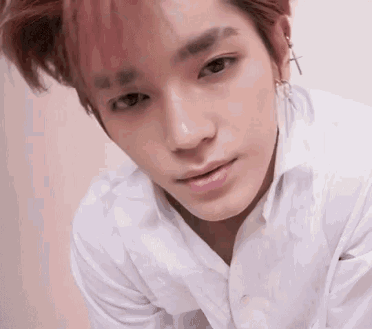 a close up of a young man wearing a white shirt