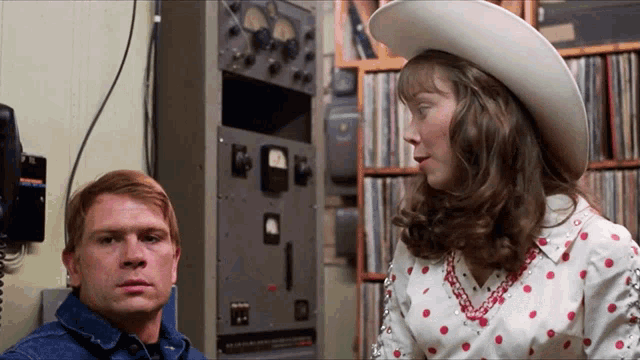 a man and a woman are talking in front of a machine that says ' lg ' on the front