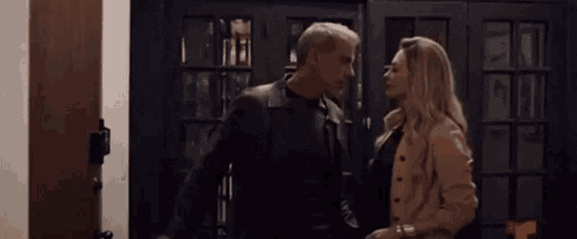 a man and a woman are standing next to each other in a room .