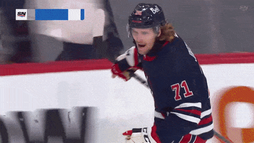 a hockey player with the number 71 on his jersey stands on the ice