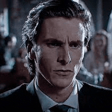 a close up of a man wearing a suit and tie .