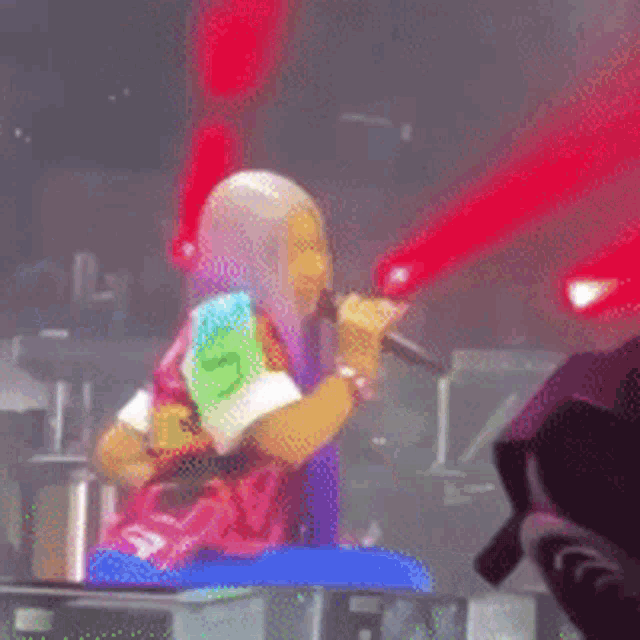 a woman with purple hair is holding a microphone and wearing a shirt that says ' s ' on it
