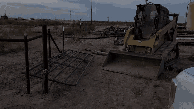 a yellow and black cat bulldozer is parked in the dirt