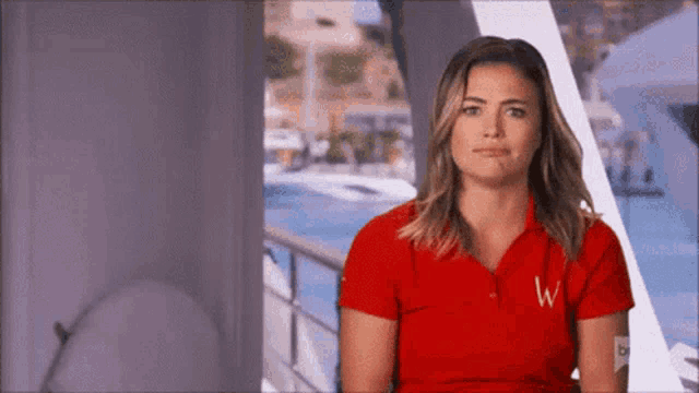 a woman wearing a red polo shirt with the letter w on it