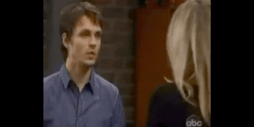a man and a woman are standing next to each other in a room .