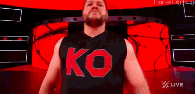 a wrestler is wearing a black tank top with the word ko on it