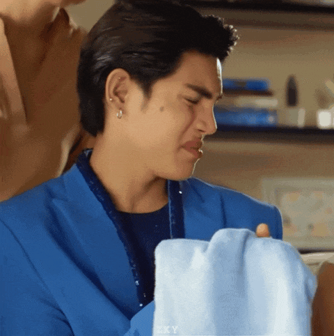 a man in a blue jacket is holding a blue cloth in his hand