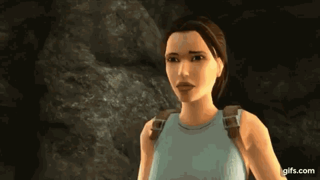 a woman in a video game is standing in front of a rock in a cave .