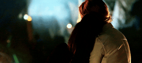 a man and a woman are hugging each other in the dark