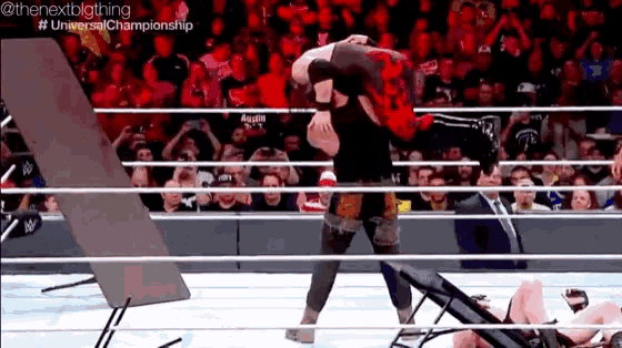 a wrestling match is taking place in front of a crowd at the universal championship