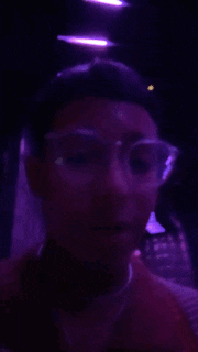 a blurry photo of a man wearing glasses and a red shirt