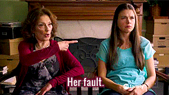two women are sitting next to each other and one of them is pointing at the other and the words her fault are visible