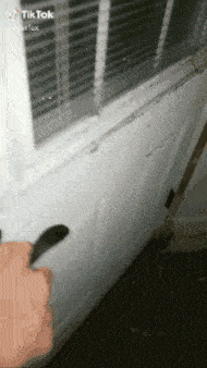 a person is holding a knife in front of a door that says tik tok on the bottom