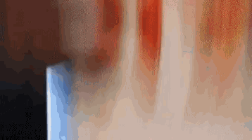 a blurry picture of a person standing in front of a wall with a blurred background .